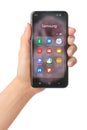 Hand holds mobile phone with icons of Samsung services mobile apps on its screen, such as: Messages, SmartThings, Voice Redorder, Royalty Free Stock Photo