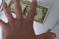 The hand holds the money in the notebook on the desk in the office. A bribe giving. corruption. Dollars for work. work done for mo