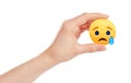 Hand holds new Facebook Sad Empathetic Emoji Reaction