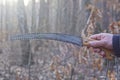 hand holds one gray iron hacksaw lopper