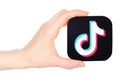 Hand holds paper TikTok mobile app icon, on transparent background. TikTok is a short-form video hosting service owned by Chinese Royalty Free Stock Photo