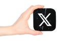Hand holds paper X - Twitter mobile app icon, on transparent background. Popular social media concept. X, formerly and still