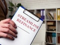 Hand holds papers for Streamline refinance and clipboard. Royalty Free Stock Photo