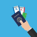 Hand holds passport airline tickets and credit card