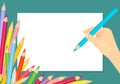 Hand holds pencil for drawing.White blank sheet of paper and scattered colored pencils. Royalty Free Stock Photo