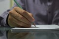 Hand holds pencil writing on  paper of notebook Royalty Free Stock Photo