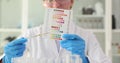 Hand holds pH indicator and compares color with scale