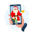 Hand holds a phone with a friendly smiling SantaÃ¢â¬â¢s contact. Snow falling on the background. Online Christmas concept.