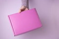 The hand holds a pink gift box closed Royalty Free Stock Photo