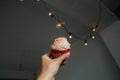 Hand holds pink sweet cupcake with sparkle Royalty Free Stock Photo