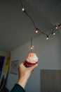 Hand holds pink sweet cupcake with sparkle Royalty Free Stock Photo