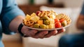 A hand holds a plate filled with assorted snacks, including Royalty Free Stock Photo