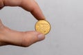 A hand holds a Polish five penny coin on a white background close-up