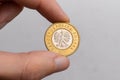 A hand holds a Polish two zloty coin on a white background close-up Royalty Free Stock Photo