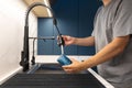 Man rinsing glass with pull out sprayer. Quick kitchen cleanup. Royalty Free Stock Photo