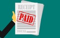Hand holds receipt with paid stamp Royalty Free Stock Photo