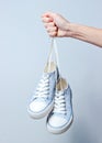 The hand holds by shoelaces retro style classic sneakers Royalty Free Stock Photo