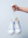 The hand holds by shoelaces retro style hipstel sneakers Royalty Free Stock Photo