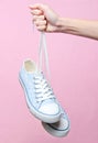 The hand holds by shoelaces retro style hipster sneakers Royalty Free Stock Photo