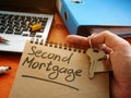 Hand holds sign second mortgage and key