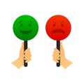 A hand holds a signboard with a green good emotion and a red negative emotion. Right and wrong for feedback. Not a