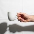 A hand holds a simple white ceramic mug against a plain white background Royalty Free Stock Photo