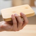 A hand holds a small rectangular wooden block with rounded corners Royalty Free Stock Photo