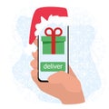 Hand holds a smartphone and orders a gift in the online store christmas distance