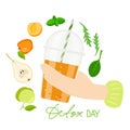 Hand holds smoothie cup. Detox day text with smoothie cup and ingredients. Plastic takeaway cup with orange liquid Royalty Free Stock Photo
