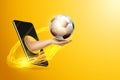 Hand holds soccer ball through smartphone on yellow background. Concept for online games, sports broadcasts, sports betting Royalty Free Stock Photo