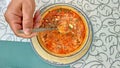 Hand holds a spoon, Delicious bright colored soup, top view