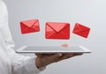 Hand holding tablet with red envelopes floating isolated on white background Royalty Free Stock Photo