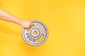 Hand holds ten-kilogram barbell dumbbell against yellow background