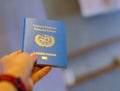 A hand holds United Nations passport. Focus on the United Nations letters