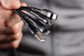 The hand holds a universal USB cable. USB Type C, Micro USB, Usb lightning Royalty Free Stock Photo