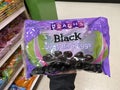 Eau Claire, Wisconsin - March 30, 2020: Hand holds up a package of Black Jelly Beans Brachs brand inside of the Easter Candy sec Royalty Free Stock Photo