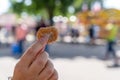 Hand holds up on sugar coated fried mini donut at state fair