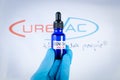 A hand holds vial in front of Curevac vaccine logo in Barcelona Spain, on May 18, 2021. Curevac is a new RNA based Covid19 vaccine