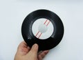 Hand holds a vinyl single record on white background