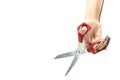 A hand holds on weight a red scissors a little open