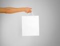 Hand holds a white gift bag Royalty Free Stock Photo