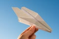 Hand holds white paper plane on sky Royalty Free Stock Photo
