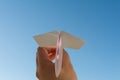 Hand holds white paper plane on sky Royalty Free Stock Photo