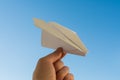 Hand holds white paper plane on sky Royalty Free Stock Photo