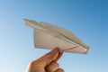 Hand holds white paper plane on sky Royalty Free Stock Photo