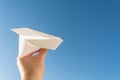Hand holds white paper plane on sky Royalty Free Stock Photo
