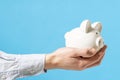 Hand holds white piggy bank  over a blue background Royalty Free Stock Photo