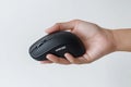 Hand holds wireless computer mouse. Modern tech gadget. Person controls device. White background. Business or tech concept. Royalty Free Stock Photo