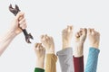 A hand holds a wrench, labor Day photography concept, closeup of the raised fist of a young womans