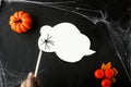 Hand holdsa white cloud for text with black spider. attributes of Halloween holiday around: orange pumpkins, cobwebs and autumn Royalty Free Stock Photo